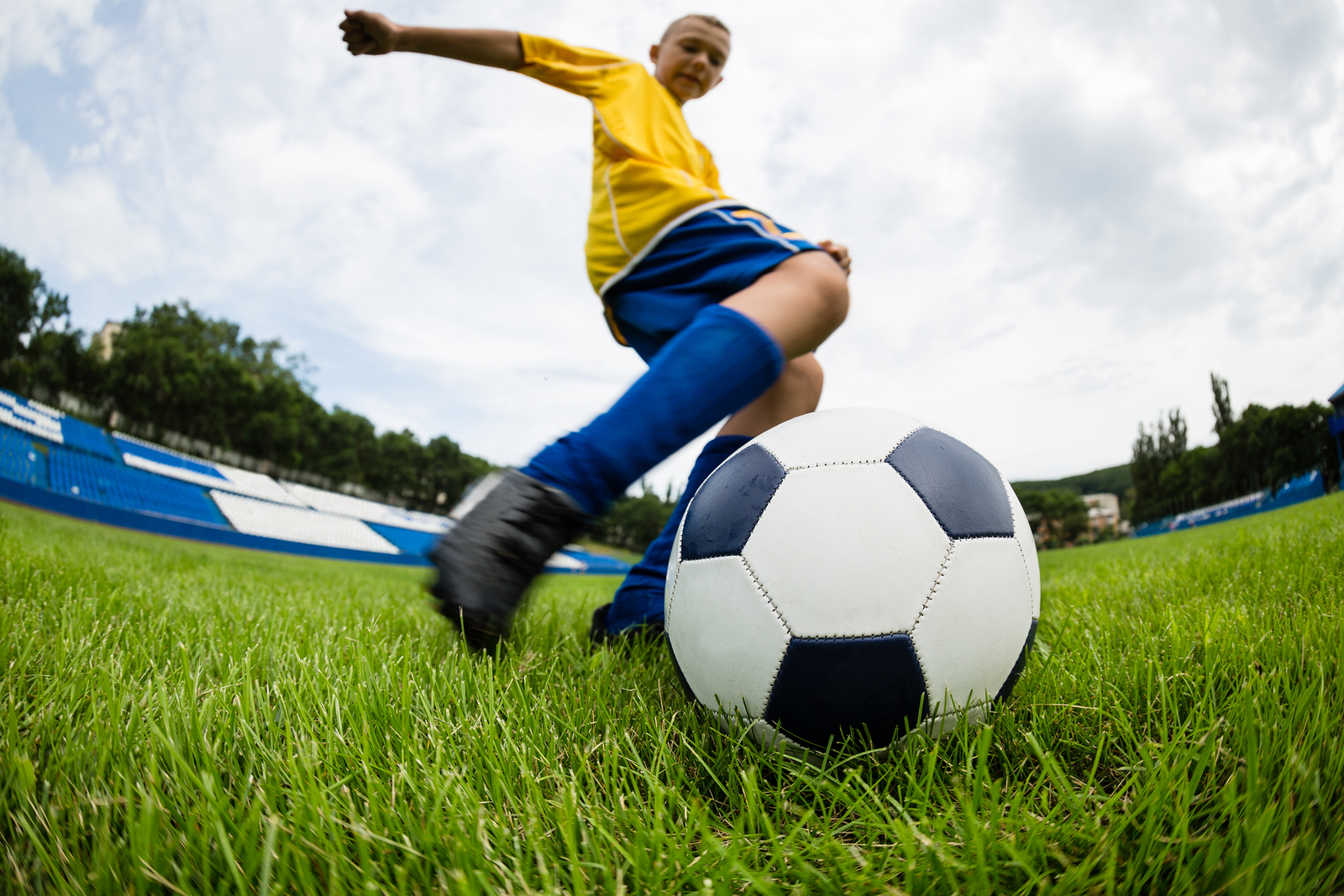 Boy Soccer Player Hits The Ball On The Football Field Fish eye 